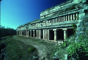 Sayil, Yucatán. The Palace. View from the second-level terrace, which is the roof of the bottom level below, looking toward the colonnade façade. This section has six openings to the interior rooms: two are simple doorways, and four are porticoed openings, each with two beautifully shaped round columns, all holding the strong horizontal frieze of colonettes.